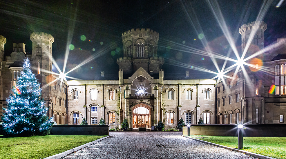 Exterior of festive Warner Hotel with Christmas trees at night